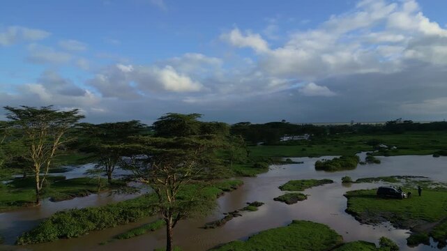 Aerial view of Ewaso Narok River winding through the savanna landscape with acacia trees in Rumuruti, Laikipia County, Kenya.