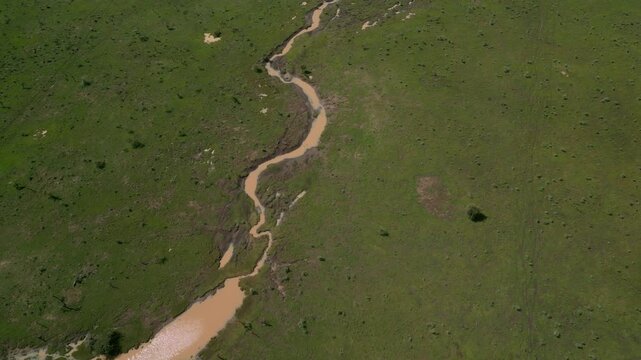 Aerial view of Ewaso Narok River winding through the lush green savanna landscape in Rumuruti, Laikipia County, Kenya.