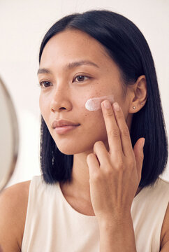 Woman applying facial cream with fingers for skincare routine and moisturizer demonstration for beauty website background