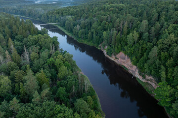 Fototapeta premium Aerial view of Velnala sandstone cliffs and the Gauja River at sunrise in Gauja National Park, Sigulda, Latvia