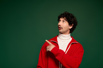Obraz premium Young man with moustache pointing in a vibrant studio setting during Movember celebration