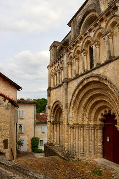 The richly carved Romanesque fa&ccedil;ade of the Church of Saint-Jacques rises above a quiet historic street in Aubeterre-sur-Dronne, one of the picturesque heritage villages of the Charente region in south