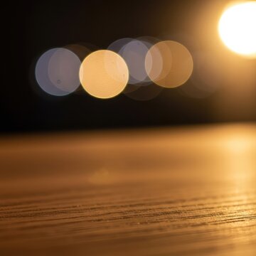 Detailed close-up view showing sharp texture of natural wood grain contrasting strongly with the softly blurred background light bokeh effect, natural, blurred, luminosity