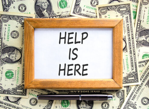 Help is here and support words symbol. Concept words Help is here on beautiful picture frame. Beautiful dollar bills background. Dollar bills. Business help is here and support concept. Copy space.