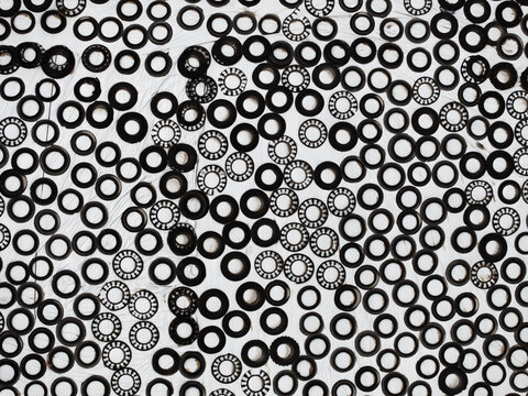 Random Arrangement of Small Metal Washers and Bearings on White Background Creating Industrial Circular Pattern