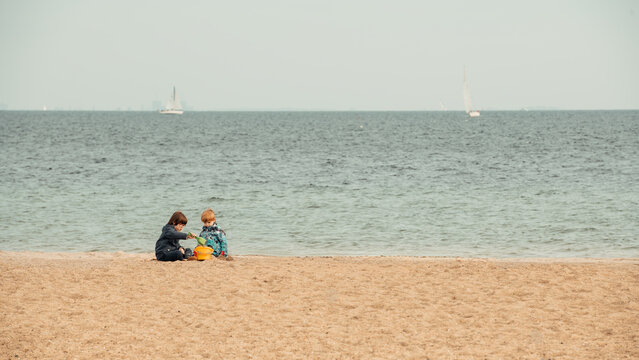 Two Young Boys Playing in the Sand on a Scenic Beach