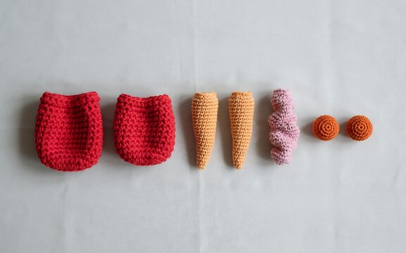 Handmade crocheted finger and toe puppets displayed in a neat row on a light fabric background