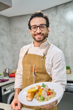Chef smiling delivering plated gourmet meal