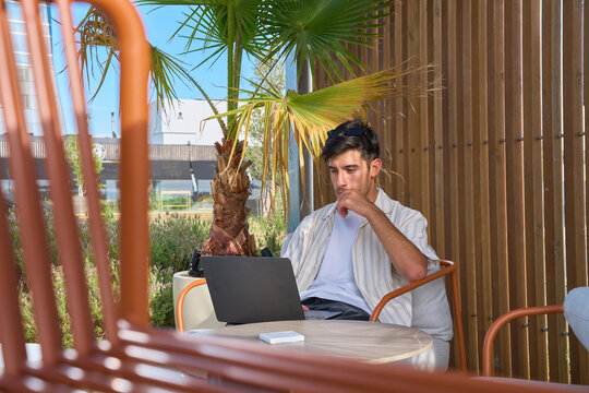 Young man concentrating on laptop during remote work