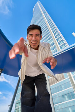 Happy man reaching out in modern city