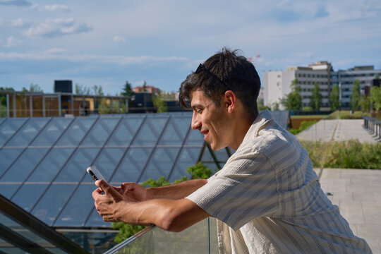 Young man using smartphone on urban terrace