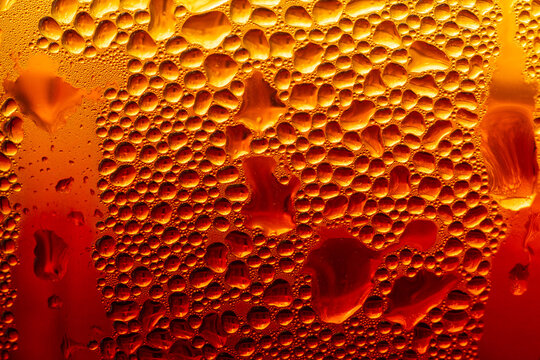 Golden Condensation Droplets on Cold Glass Surface Background,Macro,Close-up macro abstract background of water condensation and tiny water droplets covering a cold glass surface with vibrant warm gol