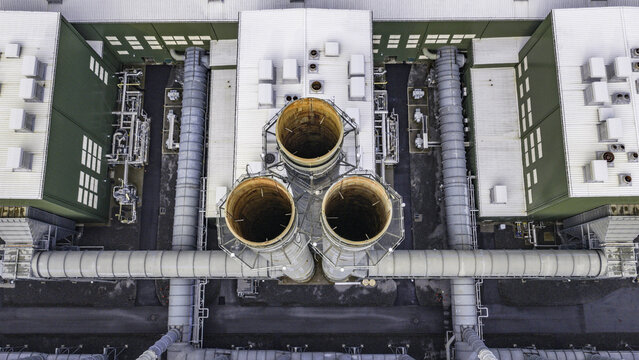 Aerial view of the Cricket Valley Energy Center featuring three large industrial exhaust stacks surrounded by metal piping and facility buildings in Dover Plains, New York, United States.
