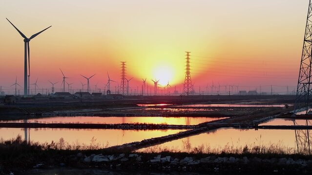 Wind farm at sunset with wetlands and reflective water surfaces in Jiangsu coastal plain