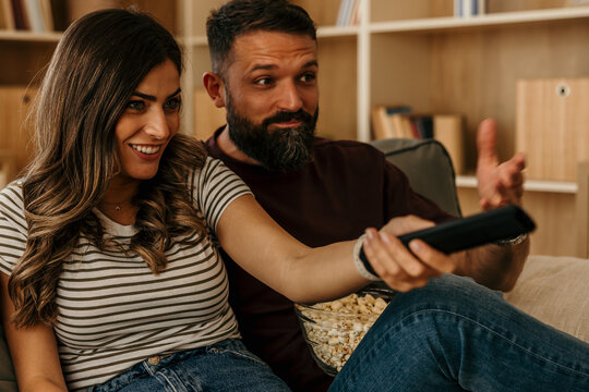 Couple watching television at home enjoying leisure time