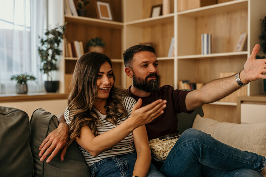 Couple relaxing at home watching movie together