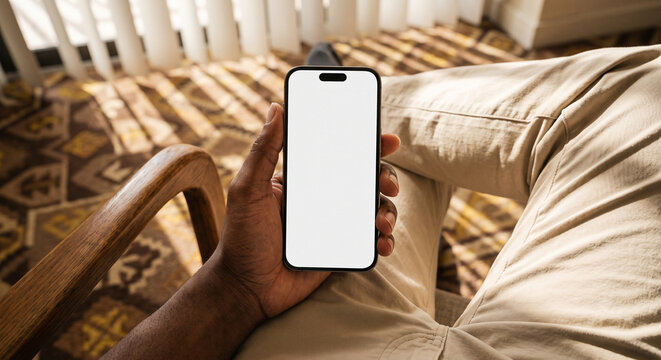 Man Holding Smartphone with Blank White Screen Mockup Indoors