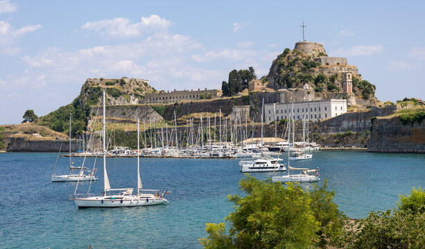 scenic view of old fortress corfu town greece with sailboat marina blue sea coast tourists and sunny summer landscape