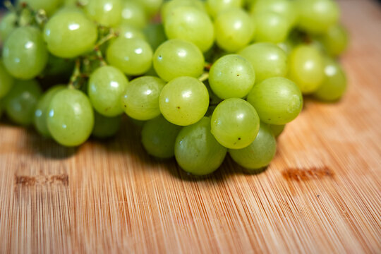 Grapes on a cutting board in the kitchen. Sweet food, healthy lifestyle, subtropical fruit, organic, fructose, raw food.