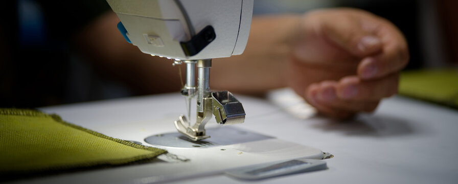 Close-up of needle guard safety comb beside sewing needle and fabric, textile production and workplace safety Photo