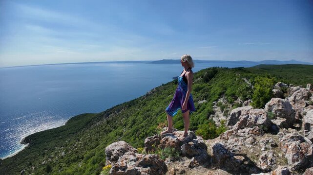 Woman enjoying the panoramic view of Sveti Ivan Beach from the historic Lubenice village on Sveti Ivan Lubenice Beach. A medieval settlement on Cres Island. Croatia of Cres Island in Croatia