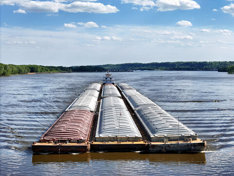 Up close front view of Tug boat pushing a set of barges on the Mississippi River