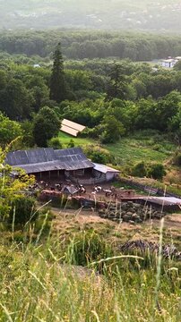 An aerial view of a traditional sheepfold and farmyard in the scenic rural hills of Iasi, Romania. Ideal for pastoral and agricultural themes.