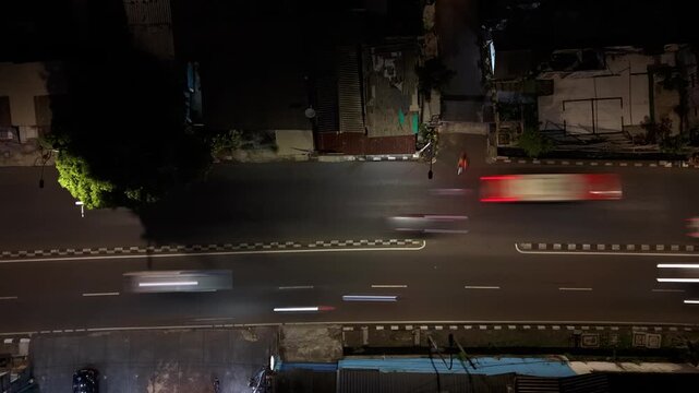 Aerial view of Jalan Panjang at night with light trails from moving vehicles in Kecamatan Kebon Jeruk, Daerah Khusus Ibukota, Indonesia.