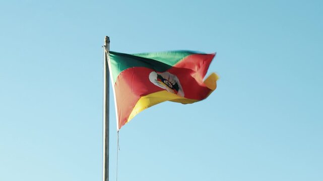 Rio Grande do Sul state flag waves against a clear blue sky, Brazil