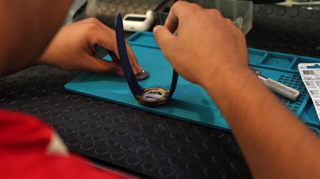 Professional watchmaker replacing a wristwatch battery