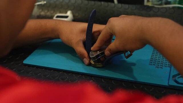 Professional watchmaker replacing a wristwatch battery