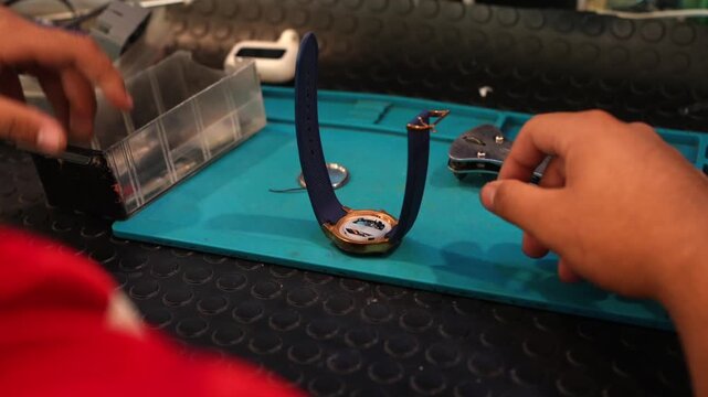 Professional watchmaker carefully repairing wristwatch mechanism
