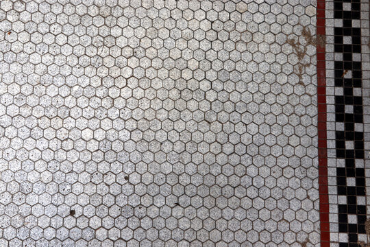 Classic white hexagonal ceramic mosaic tile floor with decorative b...