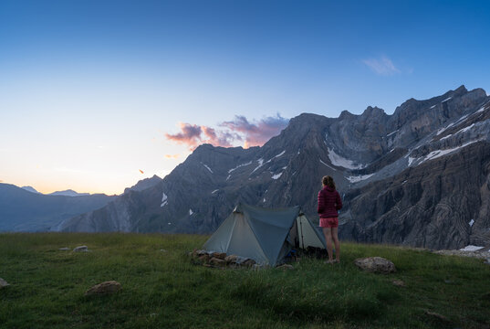 Hiker enjoying the view at dawn from her bivouac in Cirque de Gavarnie.