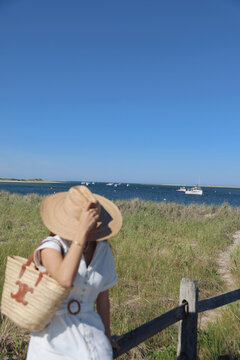 Woman in Straw Hat Enjoying Coastal Marsh View in Chatham, Cape Cod