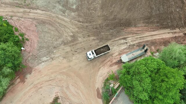 Dump truck reversing at construction site - Aerial drone view
