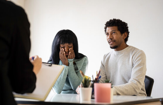 African american couple sitting at psychologist's office for a couples therapy - Couple relationship concept in trouble and crisis - Focus on man's face