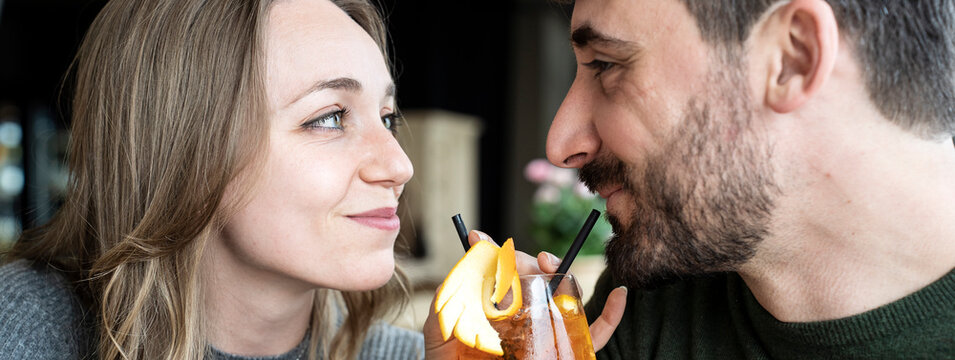 Horizontal banner or header with cool guy and young woman smiling on happy hour at cocktail bar - Young lovers couple at beginning of love story - Boyfriend and girlfriend hanging out together