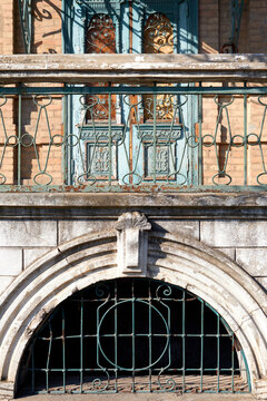 Ornate historic facade with iron railing and arched basement window detail