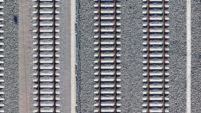 Aerial view of Koralmbahn railway tracks with gravel ballast and concrete sleepers in Deutschlandsberg, Steiermark, Austria.