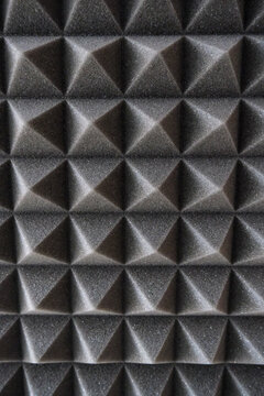 Full frame texture of dark acoustic soundproofing foam panel with pyramid structure.