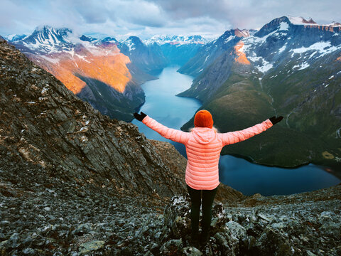 Woman traveler hiking in Norway travel vacations girl tourist raised hands enjoying Eikesdalsvatnet lake and sunset mountains aerial view, active healthy lifestyle explore Romsdal harmony with nature