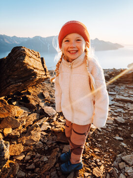 Child girl hiking in Norway family travel vacations outdoor tour, 5 years old kid scout happy smiling enjoying nature view from mountain summit healthy lifestyle candid emotions