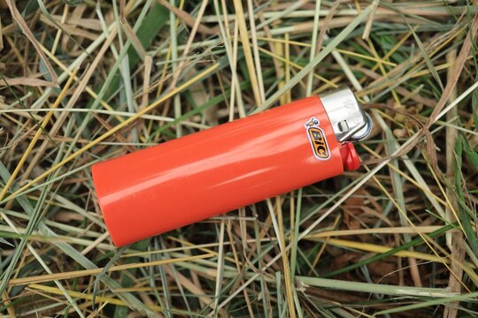 LVIV, UKRAINE - July 03, 2026: Bic Bright orange lighter on grass