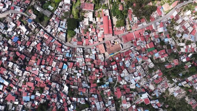 Aerial view of the dense residential area of Santiago Atitlan with red-tiled roofs and winding streets near Lake Atitlan, Santiago Atitlan, Solola Department, Guatemala.