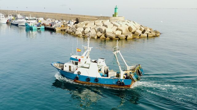 Trawler fishing boat downloading for the area of fish in the coast of Mediterranean Sea.