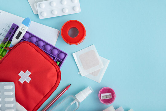 Medical supplies and first aid kit components arranged on a pastel blue background