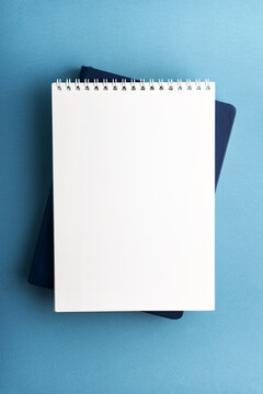 Blank spiral notebook on blue textured background