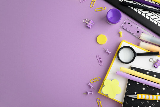 School supplies scattered on purple background
