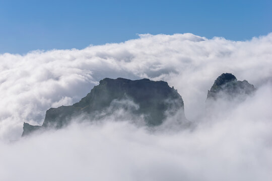 Landscape above the clouds with mountain peaks shrouded in clouds and fog
